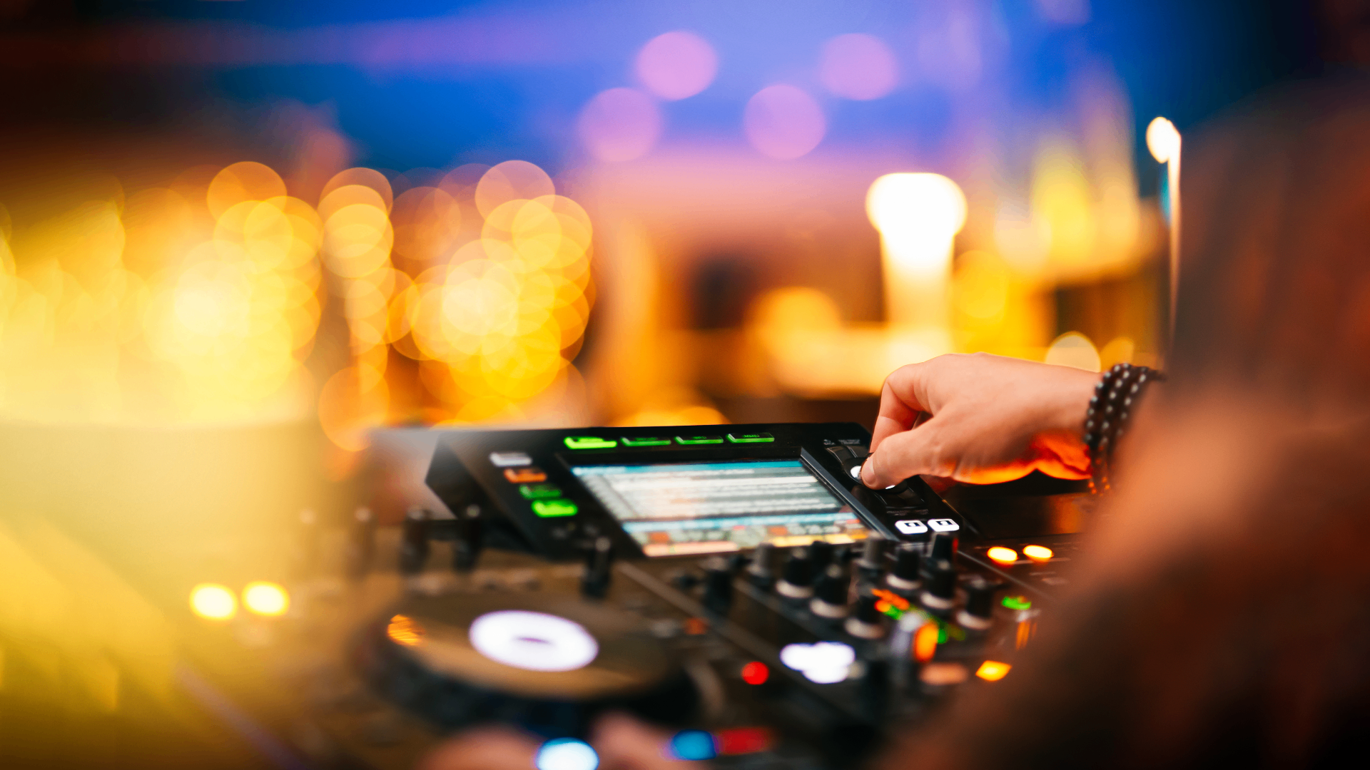 DJ mixing setup with warm golden bokeh lights in the background